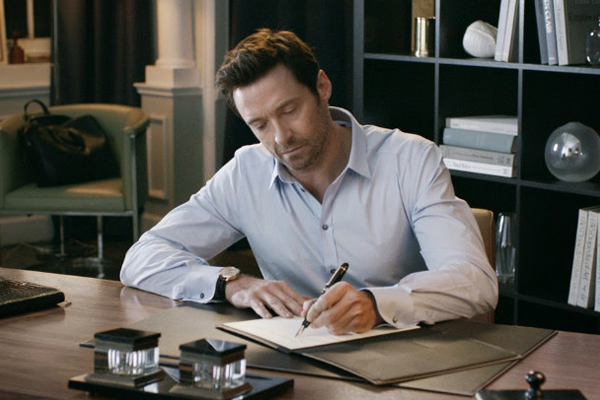 man sat at desk writing in notebook